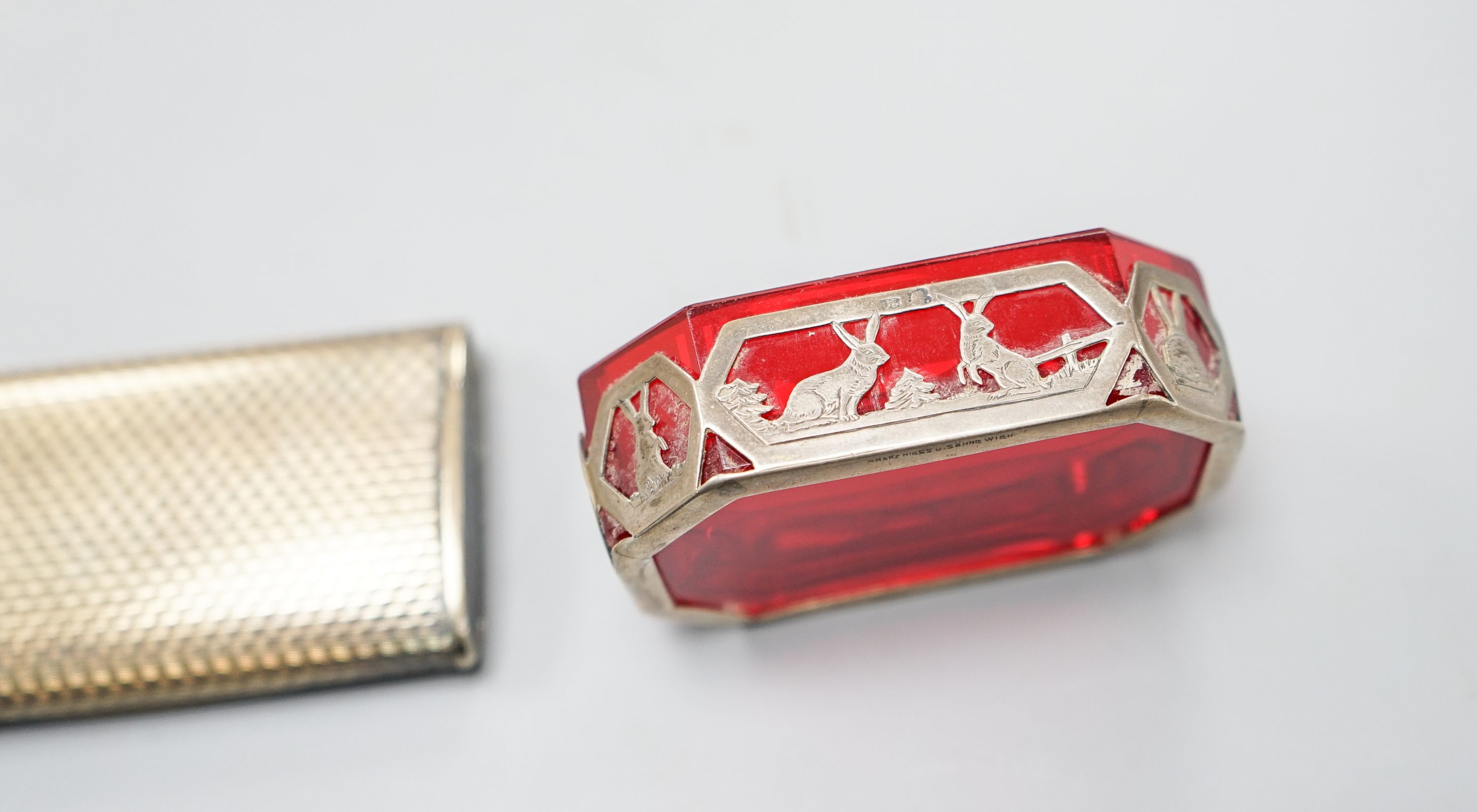 An early 20th century Austro Hungarian gilt white metal snuff box, 82mm and a similar later mounted ruby glass dish, 72mm.